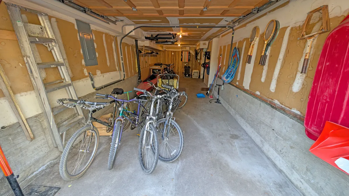 An interior view of a storage area featuring several bicycles and sporting equipment, ready for active use. The scene hints at the availability of bikes for family outings and alludes to the adventure awaiting just outside.